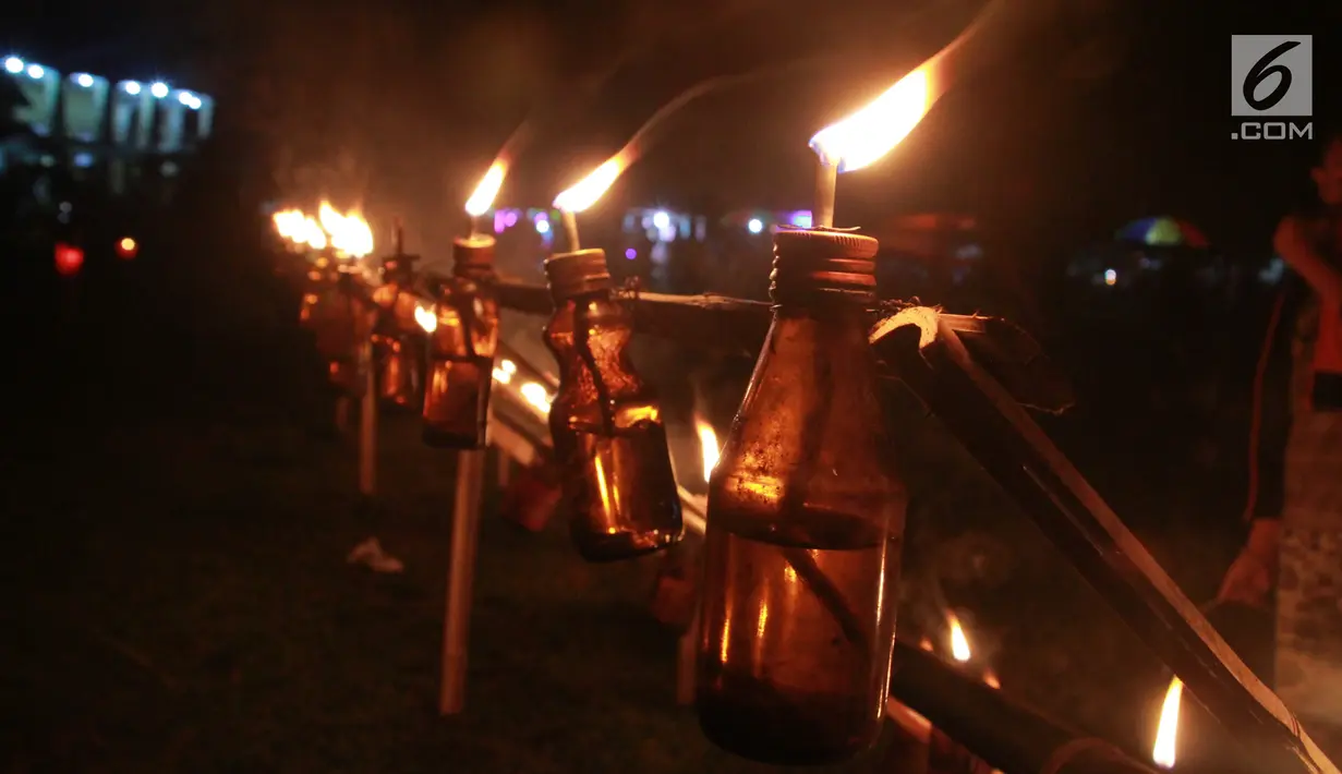 Lampu minyak yang dinyalakan saat perayaan tumbilotohe atau penyalaan berjuta lampu minyak di akhir Ramadan di Kota Gorontalo, Jumat (31/5/2019). Menurut Bupati Bone Bolango Hamim Pou, tradisi tumbilotohe akan terus dikembangkan di tahun-tahun yang akan datang. (Liputan6.com/Arfandi Ibrahim)