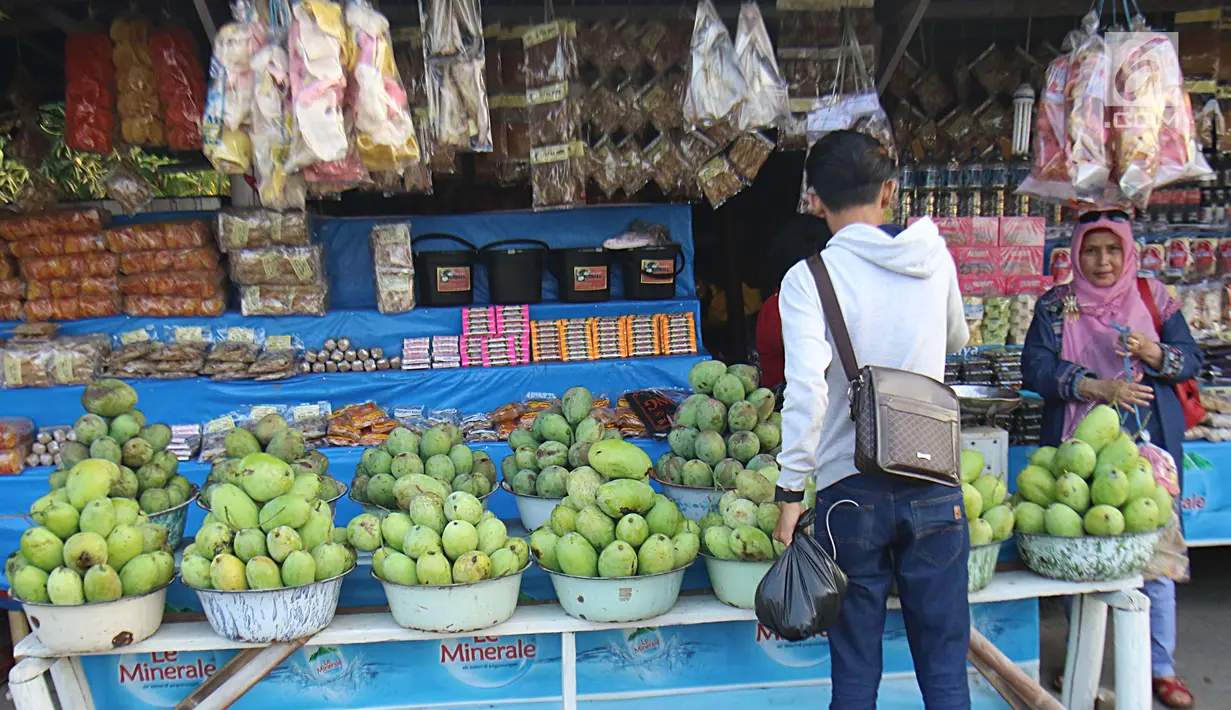 Seorang pria membeli buah mangga yang dijajakan oleh pedagang di Jalur Pantura Indramayu, Jawa Barat, Kamis (29/6). Mangga ini dijual dengan harga mulai Rp 18 ribu hinga Rp 23 ribu per kilogram tergantung jenisnya. (Liputan6.com/Helmi Afandi)