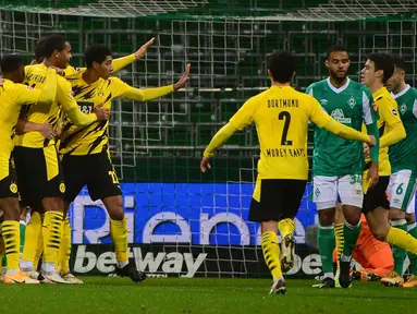 Para pemain Borussia Dortmund merayakan gol pertama yang dibuat bek Raphael Guerreiro (tengah), ke gawang Werder Bremen dalam laga lanjutan Bundesliga Liga Jerman 2020/21 pekan ke-12 di Weserstadion, Bremen, Selasa (15/12/2020). Dortmund menang 2-1 atas Bremen. (AFP/Patrik Stollarz/Pool).