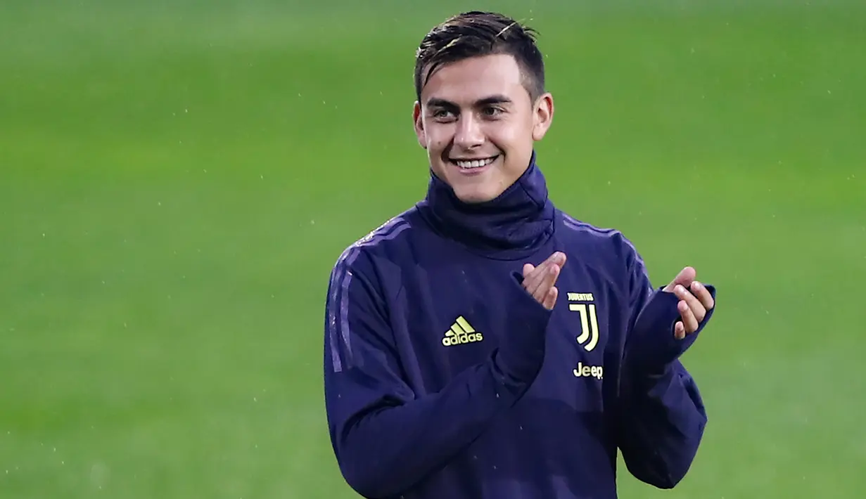 Striker Juventus, Paulo Dybala tersenyum sambil bertepuk tangan selama latihan tim di Contassina, Turin, Italia (6/11). Di pertemuan pertama Juventus menang tipis atas Manchester United 1-0 berkat Gol striker Paulo Dybala. (AFP Photo/Isabella Bonotto)
