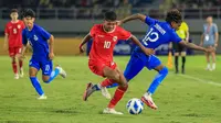 Striker Timnas Indonesia U-16, Fadly Alberto berhasil melewati adangan striker Singapura, Sarrvin Raj Kumar pada laga matchday pertama Grup A Piala AFF U-16 2024 di Stadion Manahan, Solo, Jumat (21/6/2024). (Bola.com/Radifa Arsa)