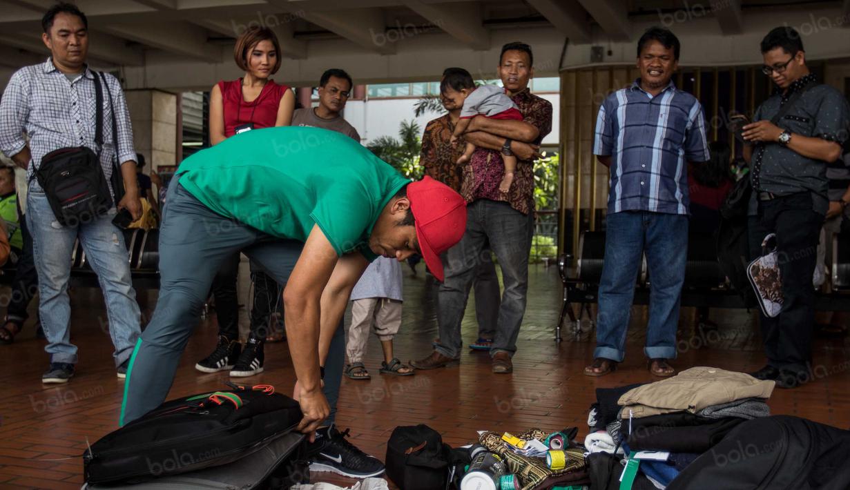 Akibat membongkar tas di pinggir jalanan bandara ini, Benny Wahyudi langsung menjadi tontonan warga yang melintas. (Bola.com/Vitalis Yogi Trisna)