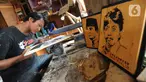 Perajin membuat kerajinan siluet kayu dari wajah tokoh nasional di kawasan Jalan Limo Raya, Depok, Jawa Barat, Rabu (20/11/2019). Siluet yang terbuat dari kayu limbah industri ini dijual dengan harga Rp 200 ribu hingga Rp 500 ribu dan dikerjakan sesuai foto dari pemesan. (merdeka.com/Arie Basuki)