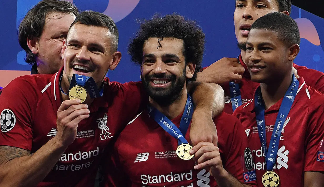 Selebrasi pemain Real Madrid (dari kiri) Dejan Lovren, Mohamed Salah dan Gerginio Wijnaldum dengan medali juara Liga Champions 2018/2019 setelah mengalahkan Tottenham Hotspur pada laga final di Wanda Metropolitano Stadium, Madrid (1/6/2019). Pada musim 2018/2019 Liverpool yang diperkuat seorang pemain Kroasia, yaitu Dejan Lovren berhasil menjuarai Liga Champions dengan mengalahkan Tottenham Hotspur 2-0 di partai final. (AFP/Paul Ellis)