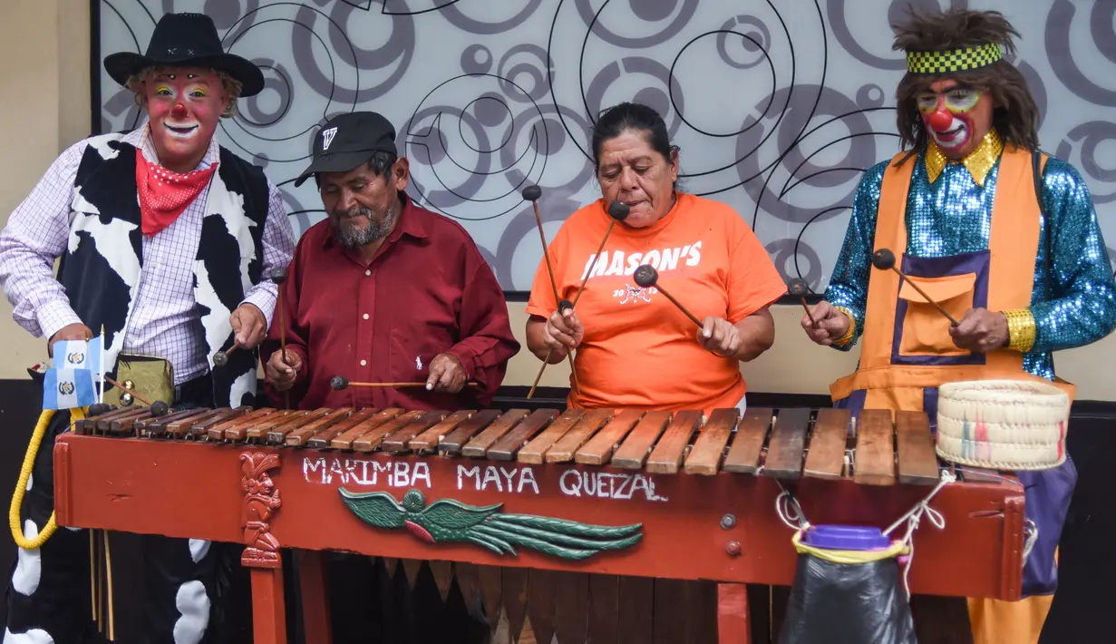 Dua badut bermain marimba selama parade pada Konvensi Badut Regional ke-5 di kota Guatemala, Rabu (19/9). Dalam acara tersebut, dengan kostum warna-warninya mereka berparade menelusuri jalanan pusat sejarah Guatemala City. (AFP / Johan ORDONEZ)
