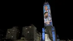 Video mapping memperlihatkan gambar bintang sepak bola Argentina Lionel Messi dan Angel Di Maria di "Monumento Nacional a la Bandera" di Rosario, Senin (21/11/2022). Proyeksi cahaya tersebut sebagai bentuk untuk menyemangati timnas Argentina sebelum menghadapi Arab Saudi dalam laga pertama Grup C Piala Dunia 2022, Selasa (22/11/2022) petang WIB. (Marcelo Manera / AFP)