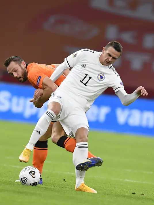 Bek Belanda, Stefan de Vrij berusaha merebut bola pemain Bosnia & Herzegovina, Smail Prevljak pada pertandingan UEFA Nations League di Johan Cruyff ArenA di Amsterdam, Belanda, Minggu (15/11/2020). Belanda menang atas Bosnia & Herzegovina 3-1. (John Thys/Pool via AP)