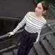Syifa mengenakan atasan off shoulder warna putih bergaris hitam dipadukan celana hitam panjang belt tali. Ia tampil dengan flat shoes berpita dan anting-anting emas. [@syifahadju]