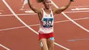 Pelari Indonesia, Nova Emilia membawa bendera merah putih usai finis di urutan kedua setelah pelari Korea Selatan Jung Hyelim pada final atletik nomor lari halang rintang 100 meter putri di Stadion Utama GBK, Jakarta (26/8). (Liputan6.com/Fery Pradolo)