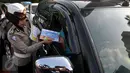 Polisi wanita dari Polda Metro Jaya membagikan peta mudik 2015 kepada pengendara di kawasan Bundaran HI, Jakarta, Jumat (26/6/2015). Pembagian peta tersebut diharapkan mampu meningkatkan keselamatan dalam bermudik. (Liputan6.com/Johan Tallo)