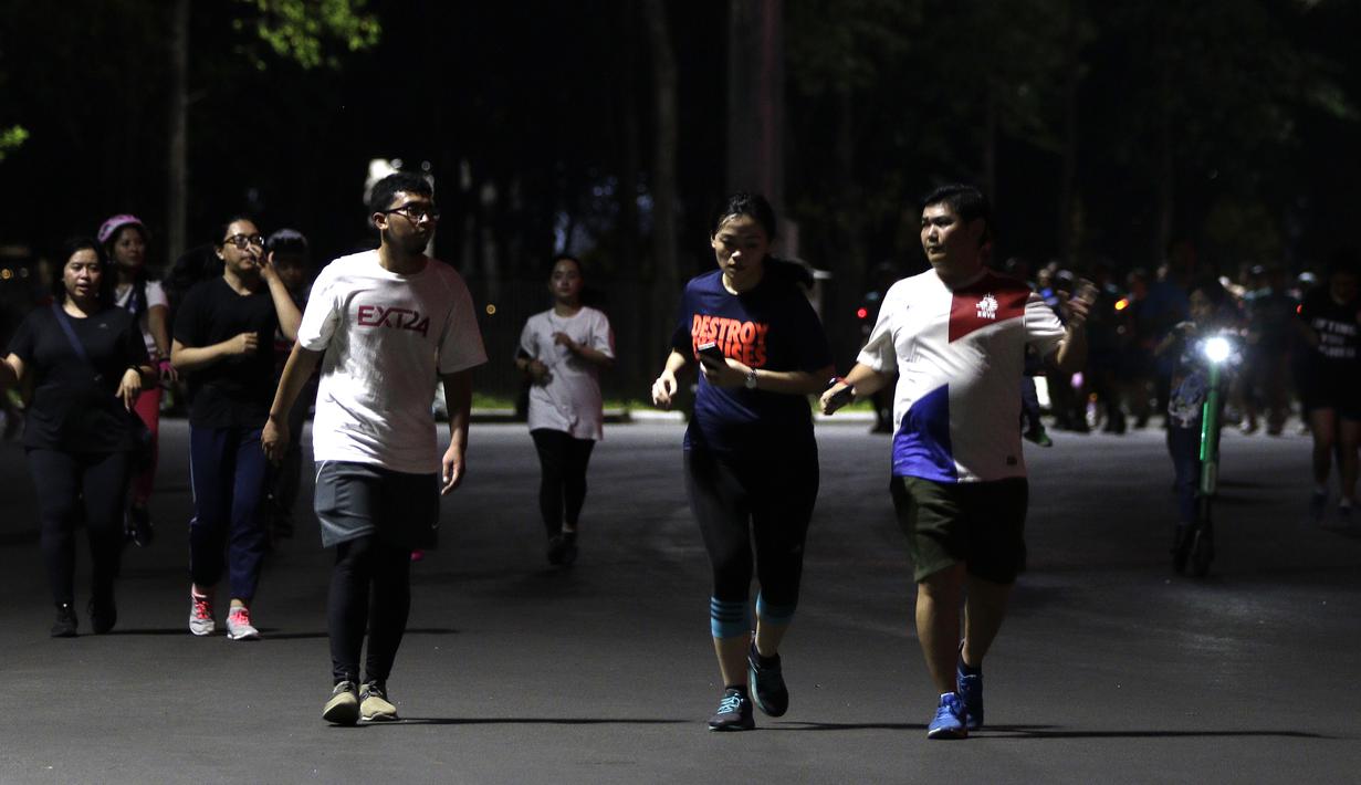 Sejumlah warga berlari di kawasan Stadion Utama Gelora Bung Karno, Senayan, Jakarta, Rabu (9/10). Olahraga lari pada malam hari di GBK menjadi pilihan pekerja ibu kota. (Bola.com/Yoppy Renato)