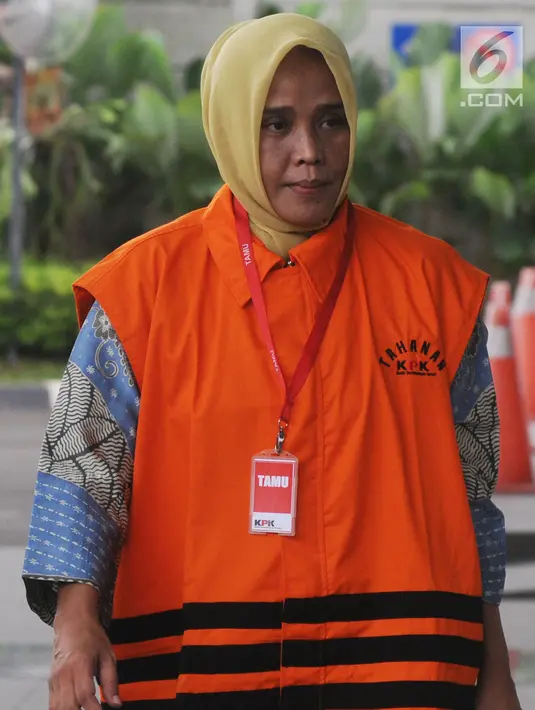 Ekspresi anggota DPRD Kota Malang Wiwik Hendri Astuti dikawal petugas berjalan menuju gedung KPK, Jakarta, Selasa (17/4).  Wiwik diperiksa perdana pasca penahanan untuk tersangka Wali Kota Malang nonaktif Mochamad Anton. (Merdeka.com/Dwi Narwoko)