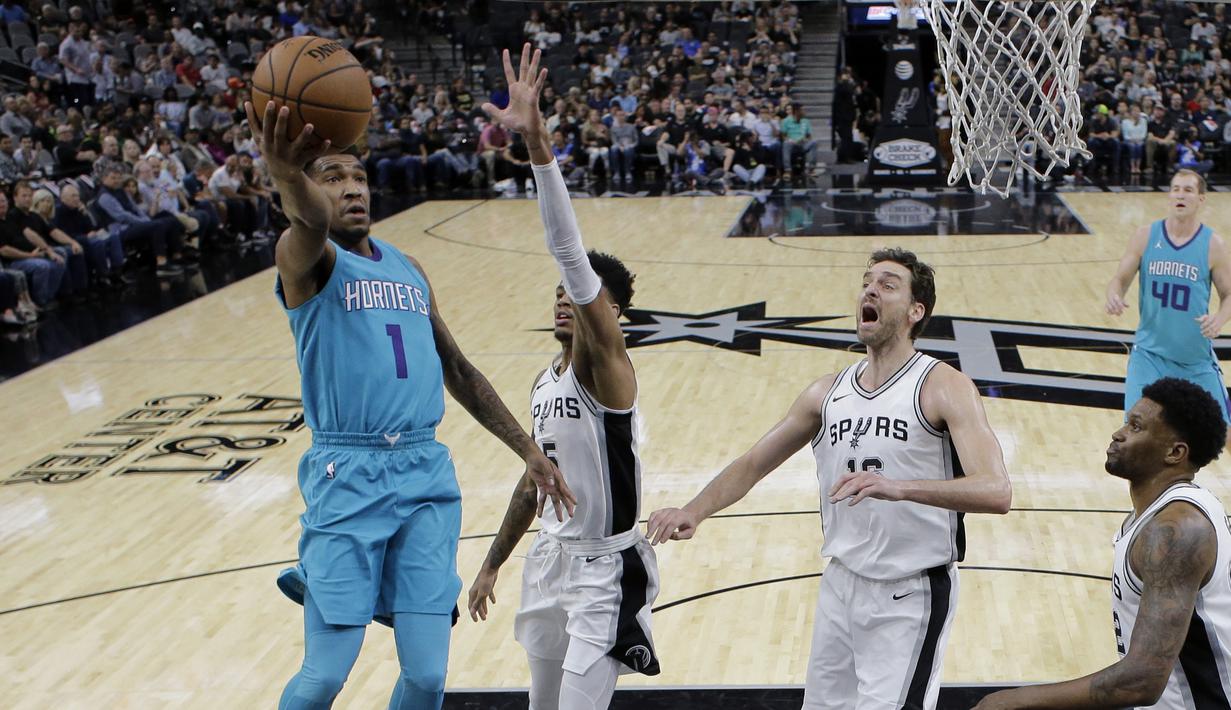 Pemain Charlotte Hornets, Malik Monk (1) mencetak skor saat melewati adangan para pemain San Antonio pada laga NBA basketball game di AT&T Center, San Antonio, (3/11/2017) waktu setempat. San Antonio menang 108-101. (AP/Eric Gay)