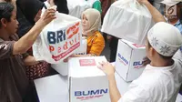 Warga menerima paket sembako Ramadan dari BUMN di di Jalan Rawa Bebek, Kecamatan Penjaringan, Jakarta Utara, Selasa (13/6). Setiap warga sudah dibekali kupon yang diberikan pihak BRI sehari sebelum pembagian. (Liputan6.com/Angga Yuniar)
