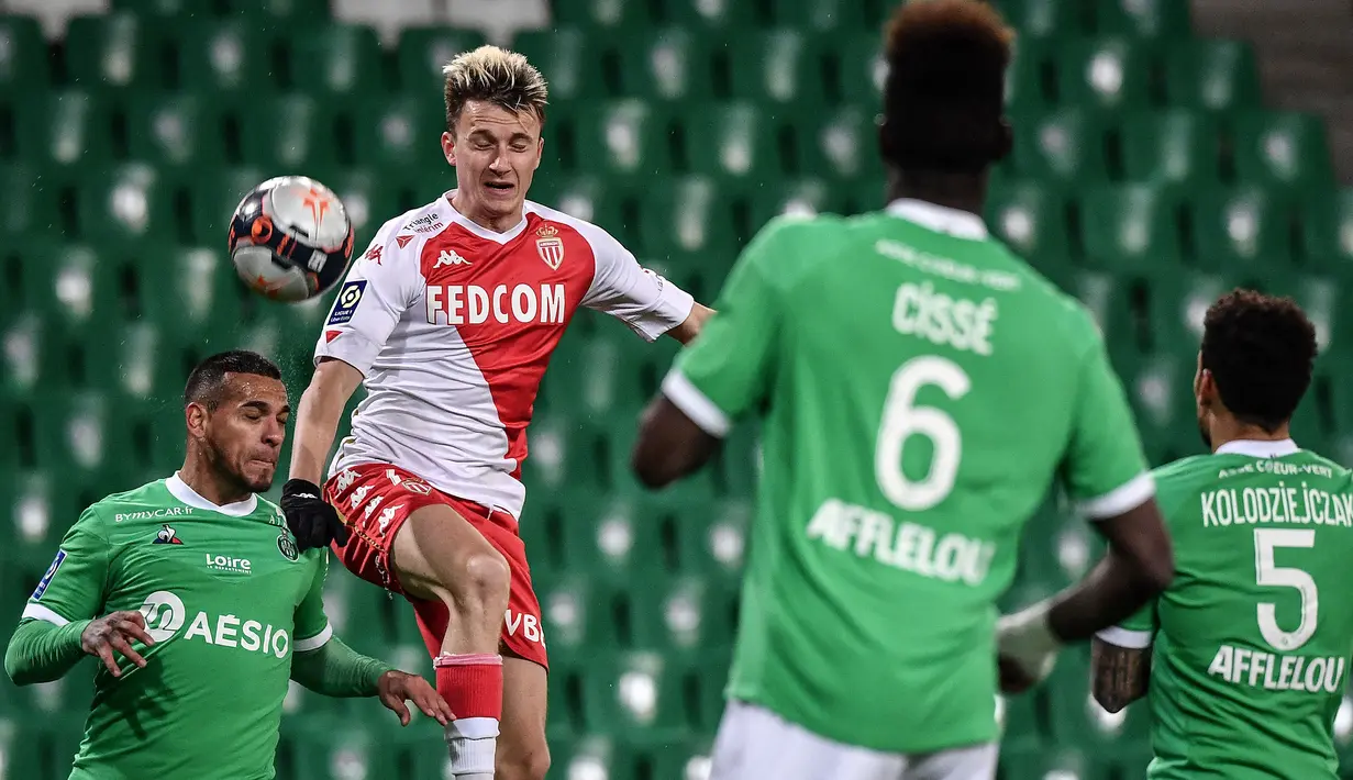 Gelandang AS Monaco, Aleksandr Golovin (tengah) berebut bola dengan bek Saint-Etienne, Miguel Trauco (kiri) dalam laga lanjutan Liga Prancis 2020/2021 pekan ke-30 di Geoffroy Guichard Stadium, Jumat (19/3/2021). Monaco menang 4-0 atas Saint-Etienne. (AFP/Jeff Pachoud)