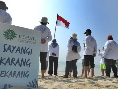 Aktivis Yayasan Kehati Jakarta  dan penjaga pulau melakukan upacara bendera menghadap laut dalam rangka HUT ke-74 RI di Pulau Sangiang, Banten, Minggu (18/8/2019). Kegiatan ini dilakukan serentak secara nasional di 73 titik untuk mencintai laut dan sumber daya alamnya. (merdeka.com/Arie Basuki)