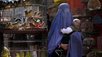 Seorang perempuan mengenakan burqa berjalan melalui pasar burung saat dia menggendong anaknya, di pusat kota Kabul, Afghanistan, 8 Mei 2022. Taliban memerintahkan perempuan Afghanistan untuk mengenakan pakaian dari kepala hingga ujung kaki atau burqa tradisional di depan umum. (AP Photo/Ebrahim Noroozi)
