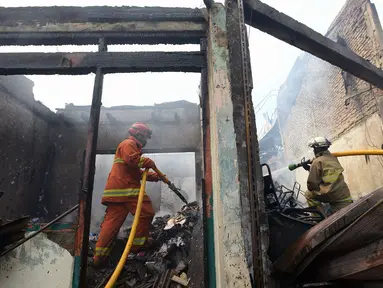 Petugas pemadam kebakaran melakukan pendinginan rumah dan kios yang terbakar di Jalan Minangkabau, Jakarta, Selasa (7/7/2020). Delapan unit mobil pemadam kebakaran dikerahkan untuk memadamkan api yang hingga saat ini belum diketahui penyebab kebakaran. (merdeka.com/Imam Buhori)