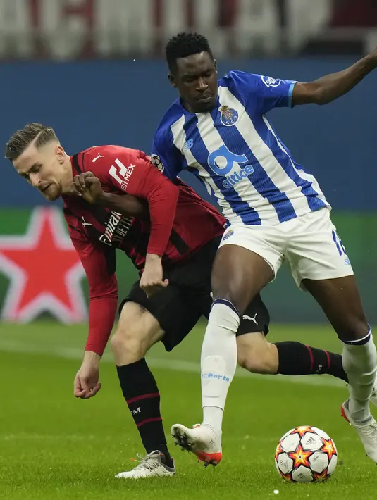 Gelandang AC Milan Alexis Saelemaekers berebut bola dengan bek FC Porto, Zaidu Sanusi pada matchday kelima Grup B Liga Champions di San Siro, Kamis (4/11/2021) dini hari WIB. AC Milan  makin terpuruk setelah hanya mampu bermain imbang dengan Porto 1-1. (AP Photo/Luca Bruno)