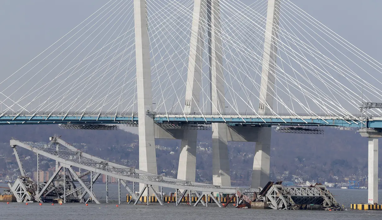 Bagian Jembatan Tappan Zee jatuh ke Sungai Hudson usai dihancurkan dengan ledakan dahsyat di Tarrytown, New York, AS, Selasa (15/1). Proses pembersihan Jembatan Tappan Zee yang hancur akan diangkut menggunakan kapal. (AP Photo/Seth Wenig)