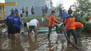 Petugas dibantu warga saat menyedot air yang menggenangi kawasan Perumahan Pantai Mutiara, Jakarta, Sabtu (4/6). Akibat tanggul jebol kawasan tersebut tergenang dengan ketinggian 50-60 sentimeter. (Liputan6.com/Gempur M Surya)