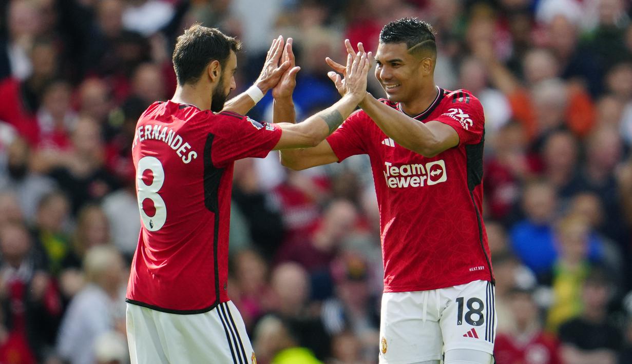 Pemain Manchester United, Bruno Fernandes (kiri) dan Casemiro, melakukan selebrasi setelah keduanya mencetak gol ke gawang Nottingham Forrest dalam pertandingan pekan ketiga Premier League 2023/2024 yang berlangsung di Old Trafford, Manchester, Inggris, Sabtu (26/8/2023). (AP Photo/Jon Super)