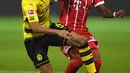 Gelandang Dortmund Jeremy Toljan berusaha membawa bola dari kawalan bek Bayern Munchen, David Alaba pada pertandingan Bundesliga Jerman di Dortmund, (4/11). Munchen menang telak 3-1 atas Dortmund. (AFP Photo/Patrik Stollarz)