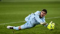 Kiper Real Madrid, Thibaut Courtois, berusaha menangkap bola saat melawan Elche pada laga Liga Spanyol di Stadion Manuel Martinez Valero, Rabu (30/12/2020). Kedua tim bermain imbang 1-1. (AP/Jose Breton)