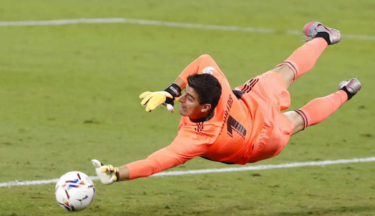 Kiper Real Madrid, Thibaut Courtois, melakukan penyelamatan saat melawan Real Betis pada laga La Liga di Stadion Benito Villamarin, Minggu (27/9/2020). Real Madrid menang dengan skor 3-2. (AP Photo/Angel Fernandez)