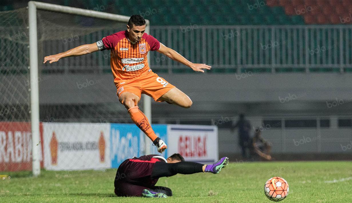 Striker Borneo FC, Pedro Javier, lompat menghindari kiper PS TNI, Teguh Amiruddin. Meski berstatus sebagai tamu namun Borneo FC bermain lebih menyerang dibanding PS TNI. (Bola.com/Vitalis Yogi Trisna)