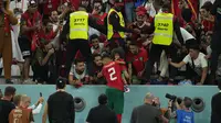 Pemain Maroko, Achraf Hakimi merayakan kemenangan timnya bersama para suporter setelah mengalahkan Spanyol pada babak 16 besar Piala Dunia 2022 yang berlangsung di Education City Stadium, Selasa (06/12/2022). (AP/Julio Cortez)