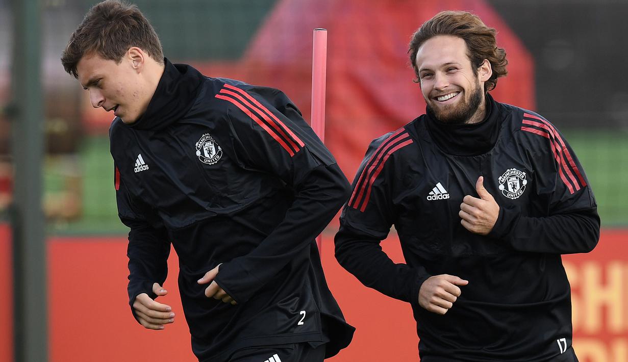 Senyum pemain Manchester United, Daley Blind (kanan) saat melakukan pemanasan bersama Victor Lindelof di club training complex, Carrington, Manchester, (11/9/2017). MU akan melawan FC Basel di grup A Liga Champions. (AFP/Paul Ellis)
