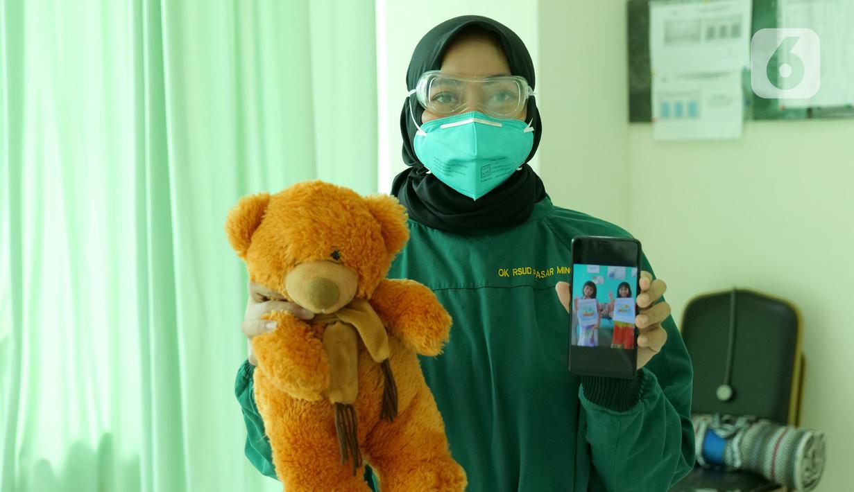 dr. Melanie Husna (34) menunjukkan foto anaknya saat di RSUD Pasar Minggu, Jakarta, Jumat (22/5/2020). Melanie Husna sudah 2 bulan tidak bertemu keluarga selama bertugas menjaga COVID -19 di RSUD Pasar Minggu. (Liputan6.com/Herman Zakharia)