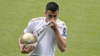 Gelandang baru Real Madrid, Reinier Jesus mencium jersey klub barunya saat presentasi dirinya di stadion Santiago Bernabeu di Madrid, Spanyol, Selasa, (18/2/2020). Reinier yang berusia 18 tahun akan dimasukkan ke tim Real Madrid Castilla. (AP Photo/Paul White)
