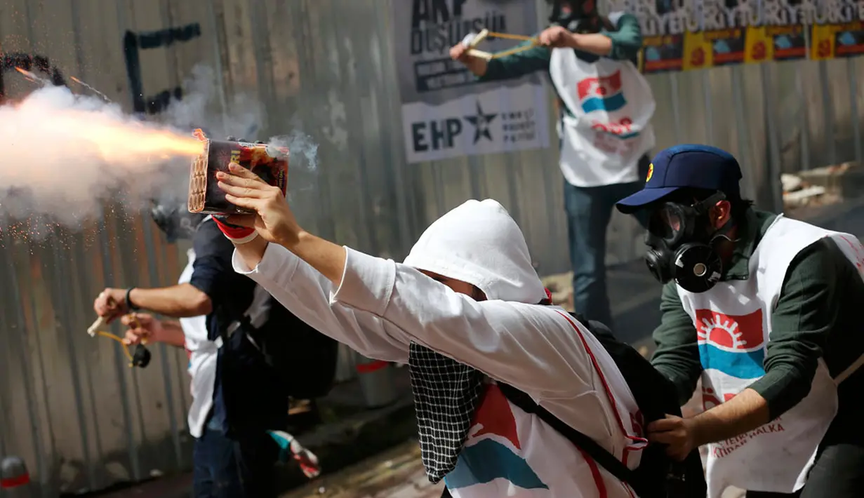 Para pengunjuk rasa menembaki polisi dengan petasan saat melakukan peringatan Hari Buruh Sedunia di pusat kota Istanbul, Turki (1/5/2014). (REUTERS/Murad Sezer)