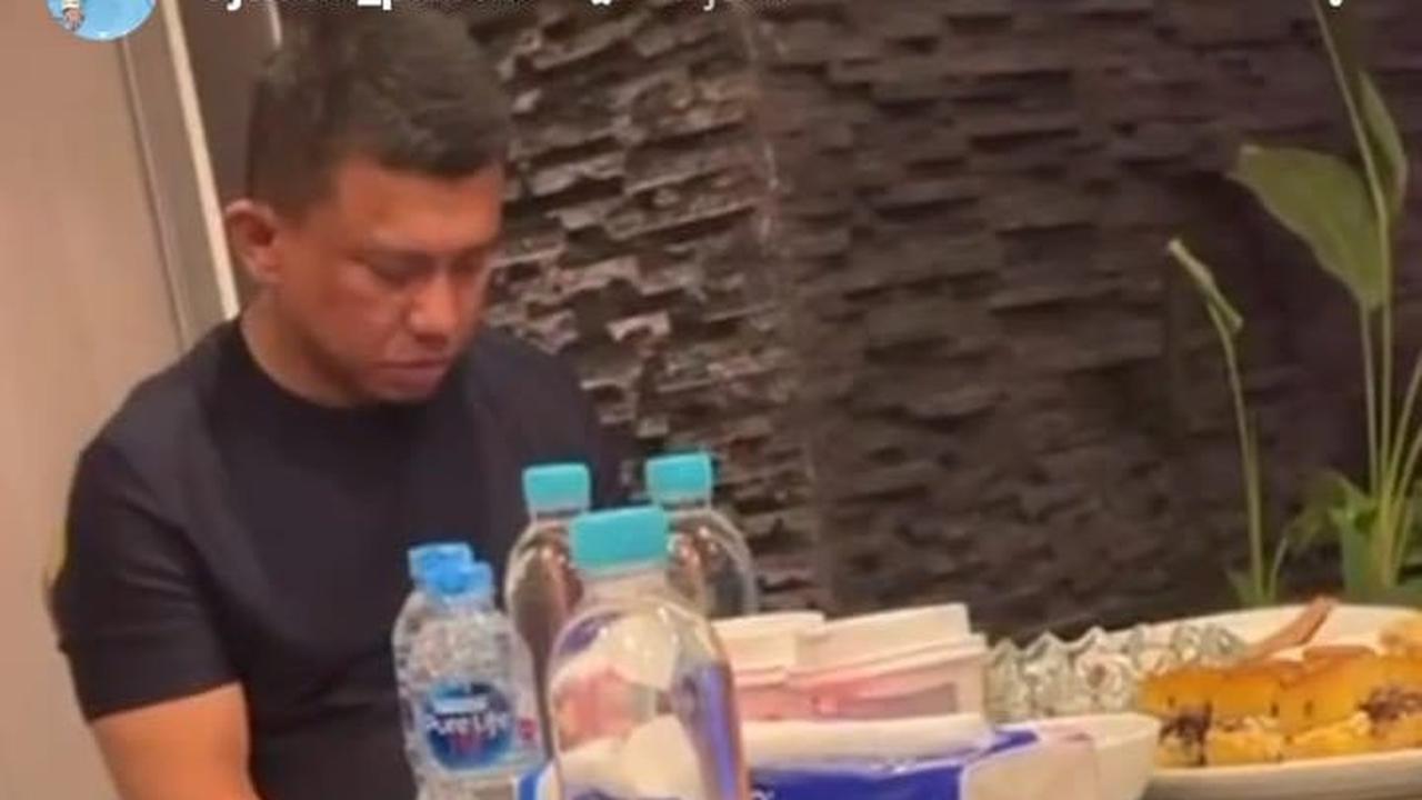 Nampak Sambo tertunduk di depan meja yang penuh makanan