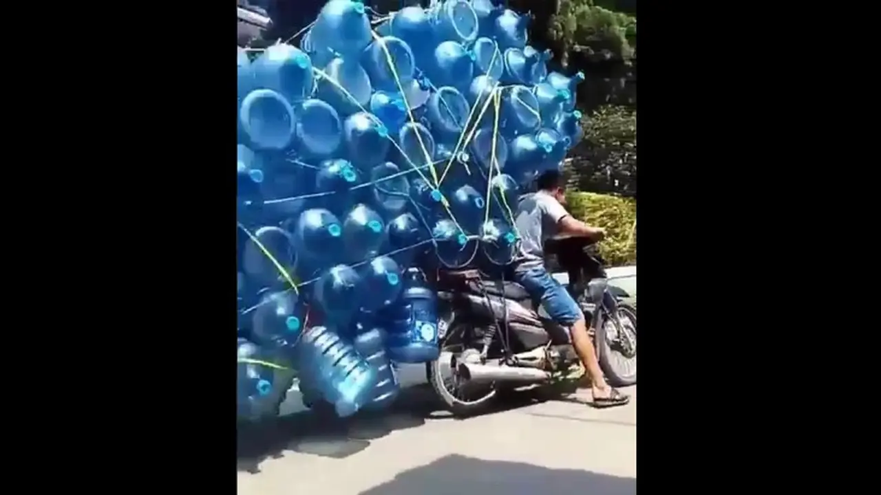 Pengendara sepeda motor membawa galon
