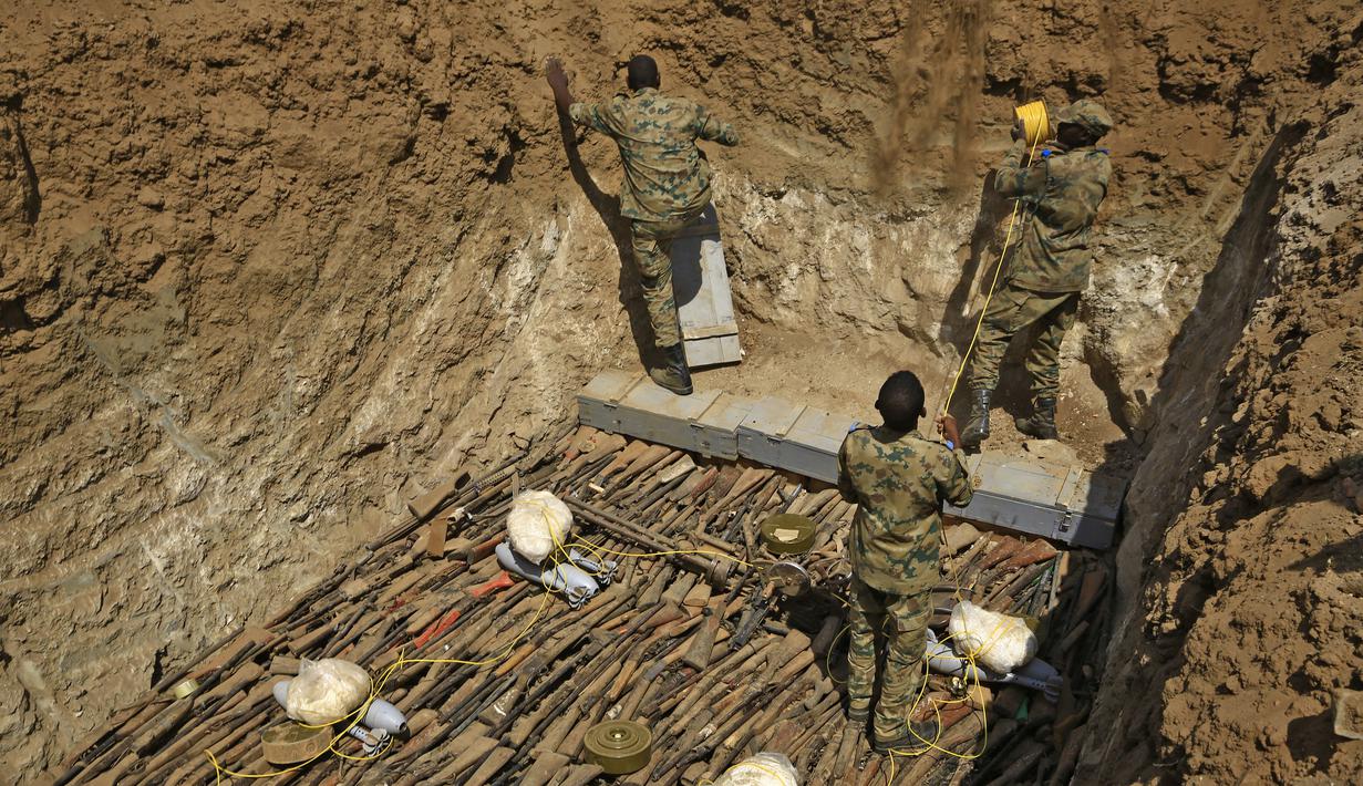 Tentara pemerintah Sudan menata senjata-senjata api milik warga sipil saat akan dihancurkan di Hajar Al Asal di Negara Bagian Sungai Nil, Sudan (29/9/2020). Diketahui ribuan senjata api ilegal yang akan dihancurkan itu merupakan milik warga sipil Sudan. (AFP/Ashraf Shazly)