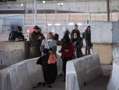 Tentara Israel memeriksa seorang perempuan Palestina saat dia menunggu untuk menyeberangi pos pemeriksaan Qalandia antara kota Ramallah Tepi Barat dan Yerusalem, untuk menghadiri sholat Jumat kedua bulan suci Ramadhan di Masjid Al-Aqsa, Jumat (23/4/2021). (AP Photo/Majdi Mohammed)
