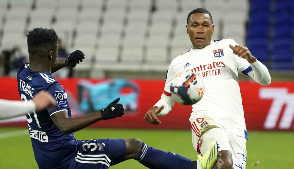 Striker Bordeaux, Amadou Traore (kiri) berebut bola dengan bek Lyon, Marcelo dalam laga lanjutan Liga Prancis 2020/21 pekan ke-22 di Groupama Stadium, Jumat (29/1/2021). Bordeaux kalah 1-2 dari Lyon. (AP/Laurent Cipriani)