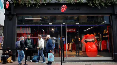 Orang-orang mengantre untuk memasuki toko andalan The Rolling Stones yang baru sebelum hari pertama pembukaannya di London, Rabu (9/9/2020). Rolling Stones membuka membuka toko pertamanya di 9 Carnaby Street. (Tolga Akmen / AFP)