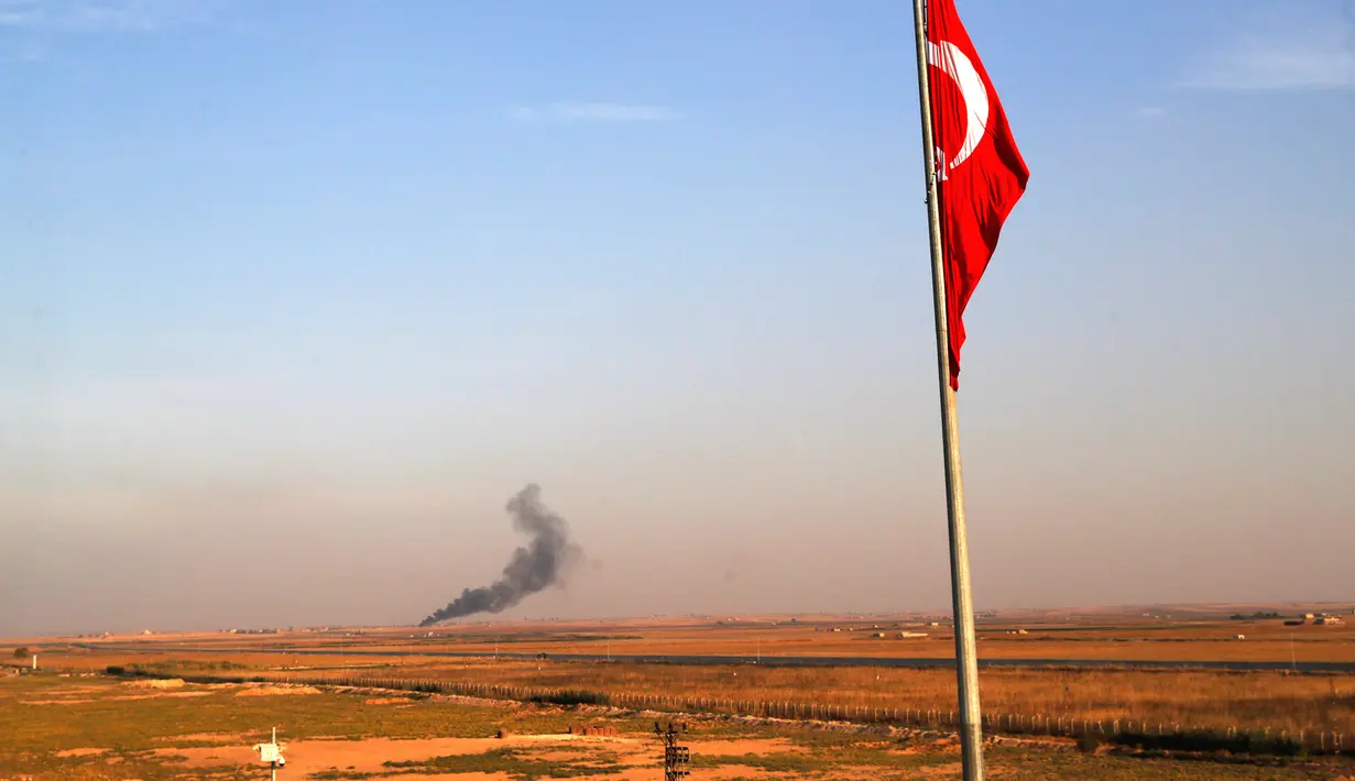 Asap mengepul setelah Turki mengebom perbatasan Suriah terlihat dari Akcakale di Provinsi Sanliurfa, Turki, Rabu (9/10/2019). Milisi Kurdi melaporkan adanya bombardir intens jet tempur Ankara di desa sipil dan pos militer Ras al-Ain, Tal Abyad, Qamishli, dan Ain Issa. (AP Photo/Lefteris Pitarakis)
