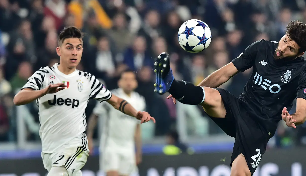 Bek Porto, Felipe (kanan) berusaha menendang bola dari kejaran penyerang Paulo Dybala pada leg kedua babak 16 besar Liga Champions di Stadion Juventus, Turin, Italia, (15/3). Juventus menang atas Porto dengan skor 1-0. (AFP Photo/Giuseppe Cacace)