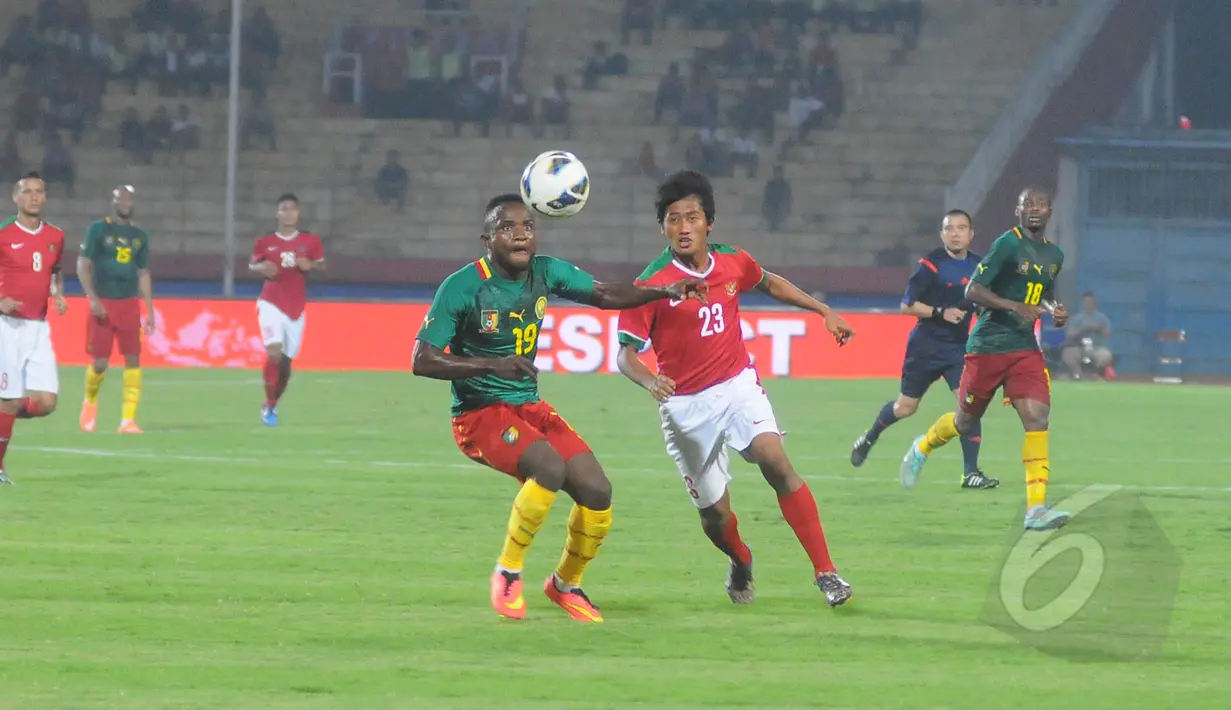 Pemain tengah Timnas Indonesia, Bayu Gatra Sanggiawan berebut bola dengan pemain Kamerun Kombi Mandjang pada laga uji coba di Stadion Gelora Delta Sidoarjo, Rabu (25/3/2015). Kamerun Menang 1-0 atas Indonesia. (Liputan6.com/Herman Zakharia)
