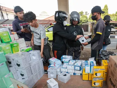 Sejumlah warga memilih masker yang dijual pedagang di kawasan bawah Tol Andara, Jakarta Selatan, di tengah kekhawatiran sebaran abu vulkanik, Minggu (6/9/2026). (KLY/Budy Santoso)