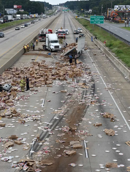 Sebuah truk pembawa pizza beku kehilangan kendali setelah melintasi jembatan di Jalan Raya Arkansas, Amerika Serikat, 9 Agustus 2017. Truk itu pun terbalik dan membuat pizza beku berserakan di jalanan. (Arkansas Department of Transportation via AP)