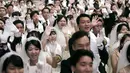 Pasangan pengantin mengangkat tangan mereka saat menghadiri upacara pernikahan massal di Cheong Shim Peace World Center, Gapyeong, Korea Selatan, Senin (27/8). (AP Photo/Ahn Young-joon)