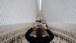 Seorang pria mengambil foto di dalam Oculus di World Trade Center Transportasi Hub, AS, Rabu (1/3). Badan Pariwisata NYC & Company mengatakan jumlah wisatawan asing berkurang sekitar 300.000 pengunjung. (Drew Angerer / Getty Images / AFP)
