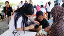 Batita sedang diperiksa kesehatannya di Mataram, NTB, Rabu (15/8). PT Hero Supermarket Tbk memberikan bantuan dan dukungan kepada lingkungan di sekitar toko yang terkena dampak bencana gempa bumi di Lombok Utara. (Liputan6.com/HO/Eko)