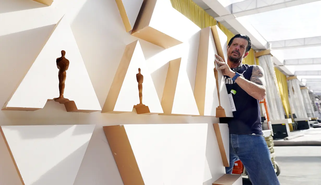 Gregg Strouth memindahkan dinding ke tempatnya dalam persiapan untuk Academy Awards ke-94 atau piala Oscar di luar Teater Dolby, Los Angeles, Rabu (23/3/2022). Ajang penghargaan Piala Oscar ke-94 akan diadakan pada Minggu, 27 Maret 2022 di Dolby Theatre Hollywood. (AP Photo/Chris Pizzello)